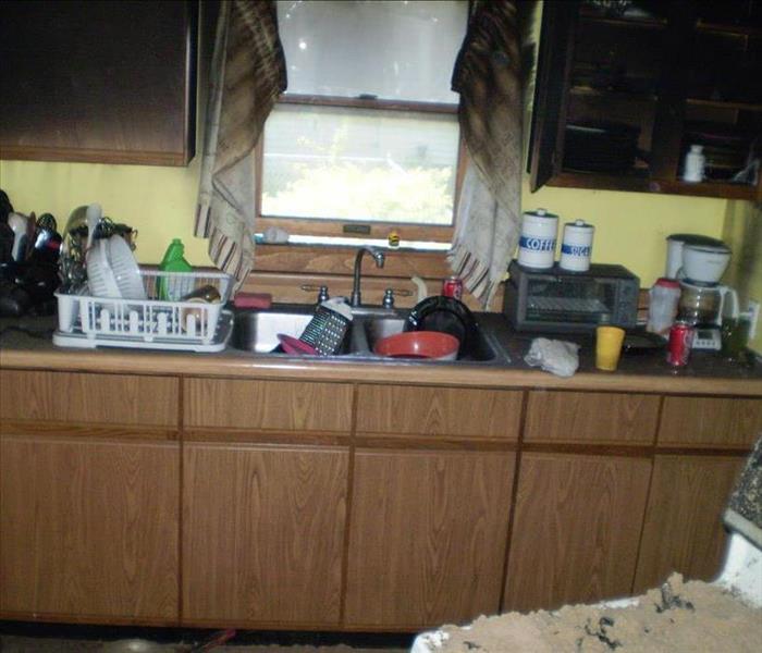 Image of kitchen with fire damage in ceiling, drapes and cabinets