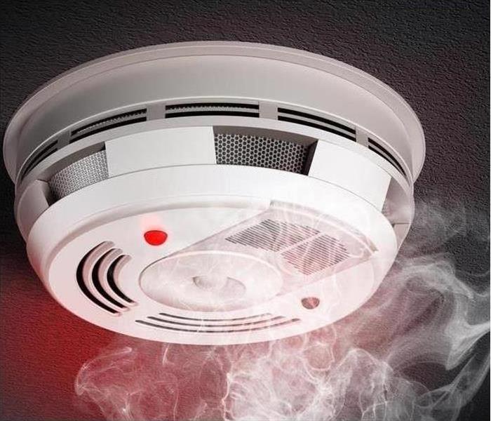 Image of a fire detector and smoke coming up to it