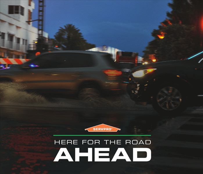 Blurred background of city and traffic, SERVPRO logo and text "Here for the road ahead"